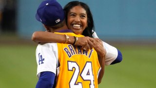 Natalia Bryant, daughter of Kobe Bryant, hugs Los Angeles Dodgers' Mookie Betts after throwing out the ceremonial first pitch prior to a baseball game between the Dodgers and the Atlanta Braves