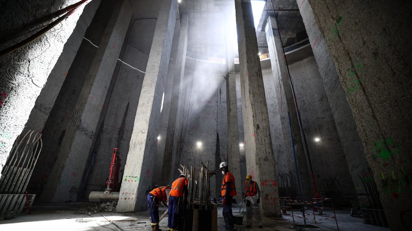 Workers stand inside the construction site of the 30-meter-deep Austerlitz basin, a river Seine water storage and treatment basin, aiming to make the river cleaner for the Paris 2024 Olympic Games.