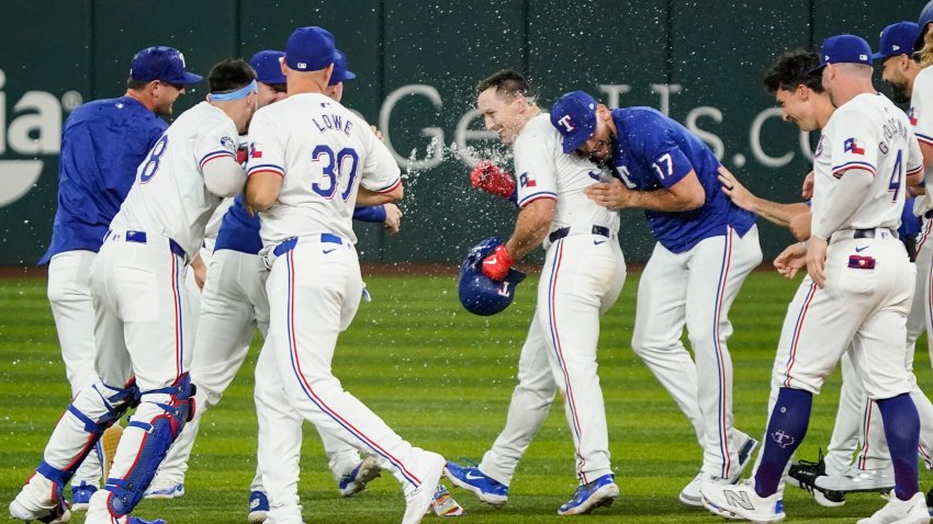 Jul 22, 2024; Arlington, Texas, USA; Texas Rangers left fielder Wyatt Langford (36) is mobbed by teammates after hitting a walk-off RBI single against the Chicago White Sox at Globe Life Field. Mandatory Credit: Raymond Carlin III-USA TODAY Sports