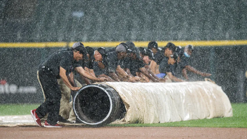 CHICAGO, ILLINOIS – AUGUST 27: The grounds crew rolls out the tarp after the start of the game between the Chicago White Sox and the Texas Rangers at Guaranteed Rate Field pauses in a rain delay on August 27, 2024 in Chicago, Illinois. (Photo by Matt Dirksen/Getty Images)